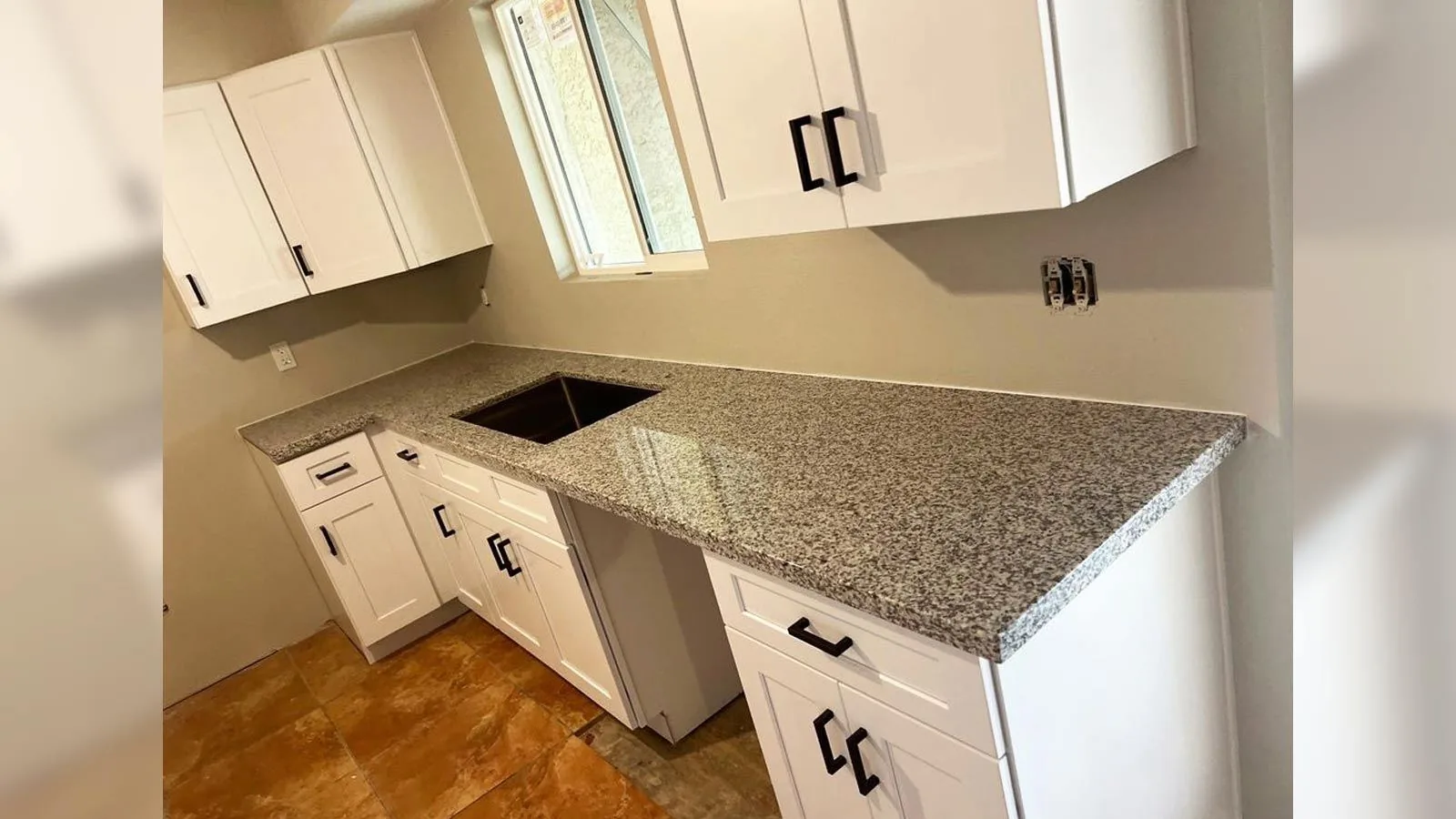 Gili White granite countertop with white shaker cabinets