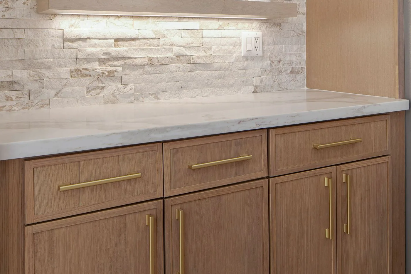 Close-up of wood shaker cabinet drawers with brass pulls