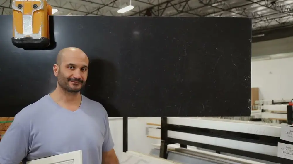 Superior team member with a black countertop slab in the warehouse