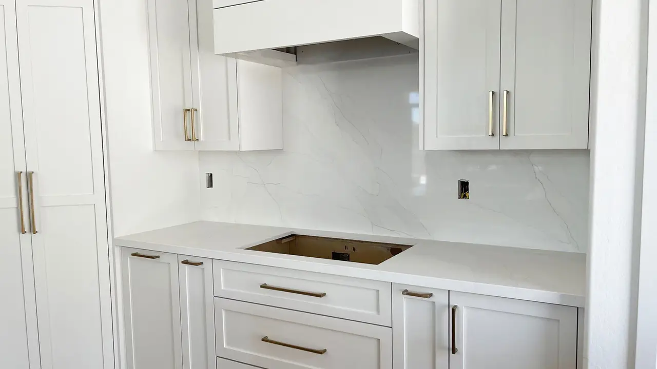 Quartz countertops and white cabinets.