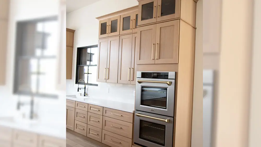Double wall ovens set into a tall run of Brighton Pearl cabinetry by Sollid