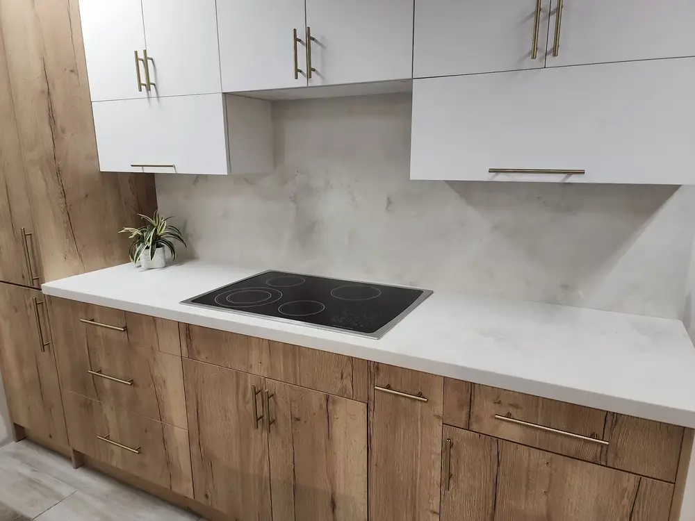 Wood base cabinets and white upper cabinets around a cooktop