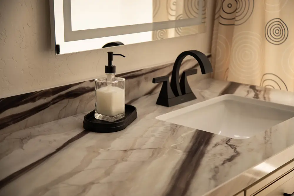 Veined vanity top below an oval mirror