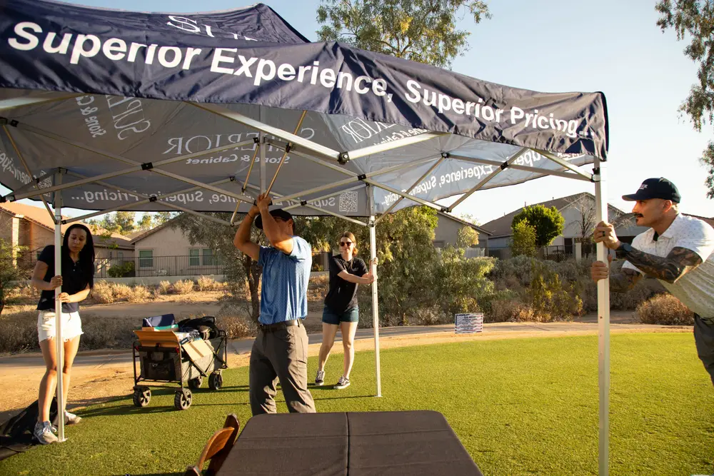 The Superior Stone & Cabinet team sets up their branded hole sponsor tent on the fairway at The Legacy Golf Resort