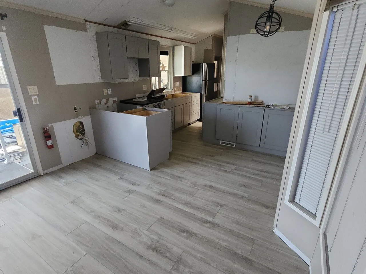 New gray wood-look luxury vinyl plank flooring in a kitchen during a remodel